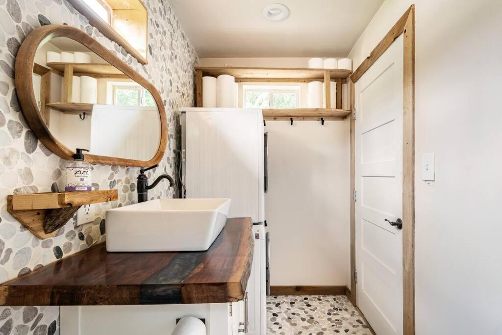 a bathroom with a sink and a mirror at Cozy Coop Casita - Lake Travis-Hot Tub-Tiny House in Austin