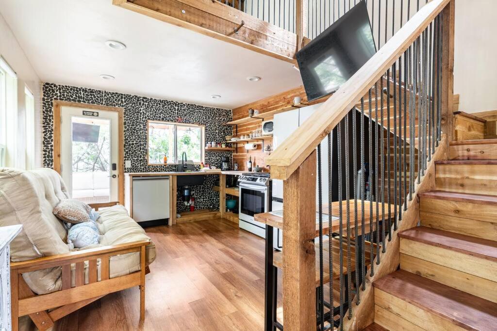 a living room with a staircase and a tv at Cozy Coop Casita - Lake Travis-Hot Tub-Tiny House in Austin