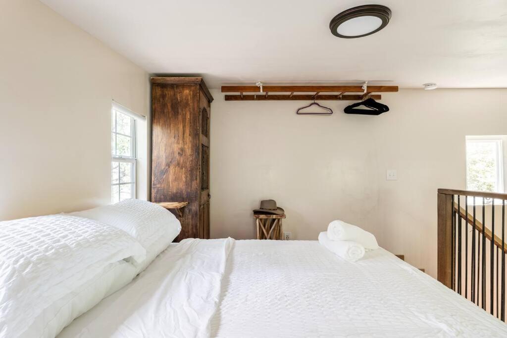 a bedroom with two white beds and a window at Cozy Coop Casita - Lake Travis-Hot Tub-Tiny House in Austin
