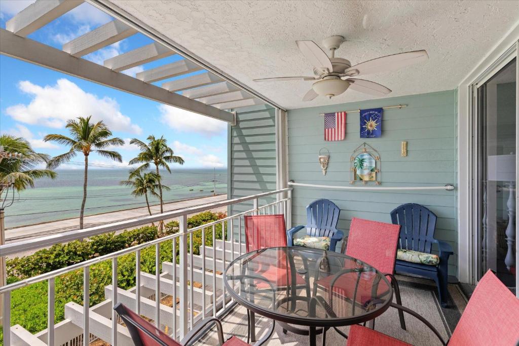 a balcony with a table and chairs and the ocean at Oceanfront Oasis in Key West