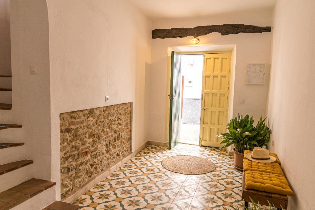 ein Wohnzimmer mit einem Kamin und einer gelben Tür in der Unterkunft Casa rural La Artística, alojamiento y arte in Fuenteheridos