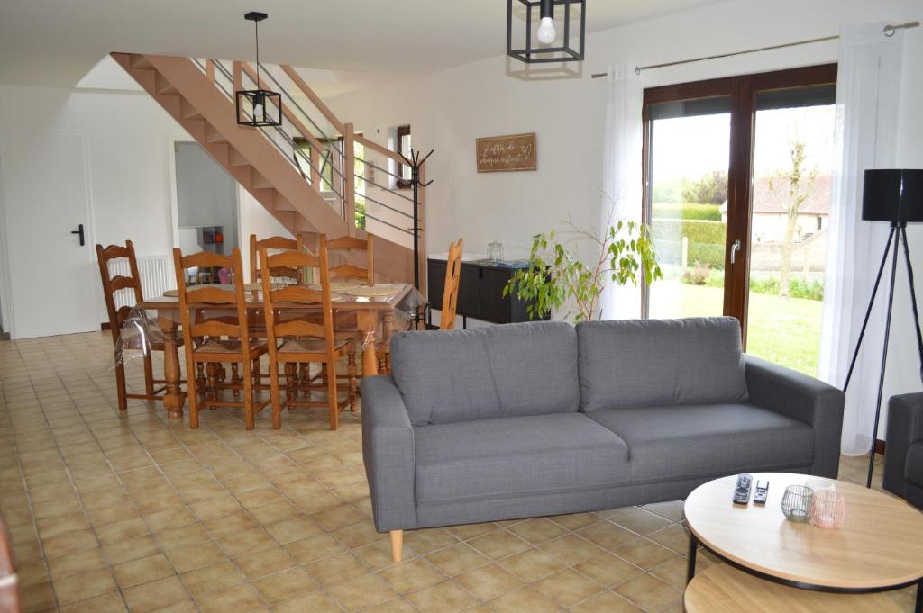 un salon avec un canapé, une table et des chaises dans l'établissement Clair Matin - Maison avec jardin privatif, à Crécy-en-Ponthieu