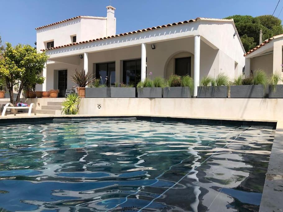 ein Haus mit einem Swimmingpool vor dem Haus in der Unterkunft Villa MAJOULIÈRE in La Ciotat