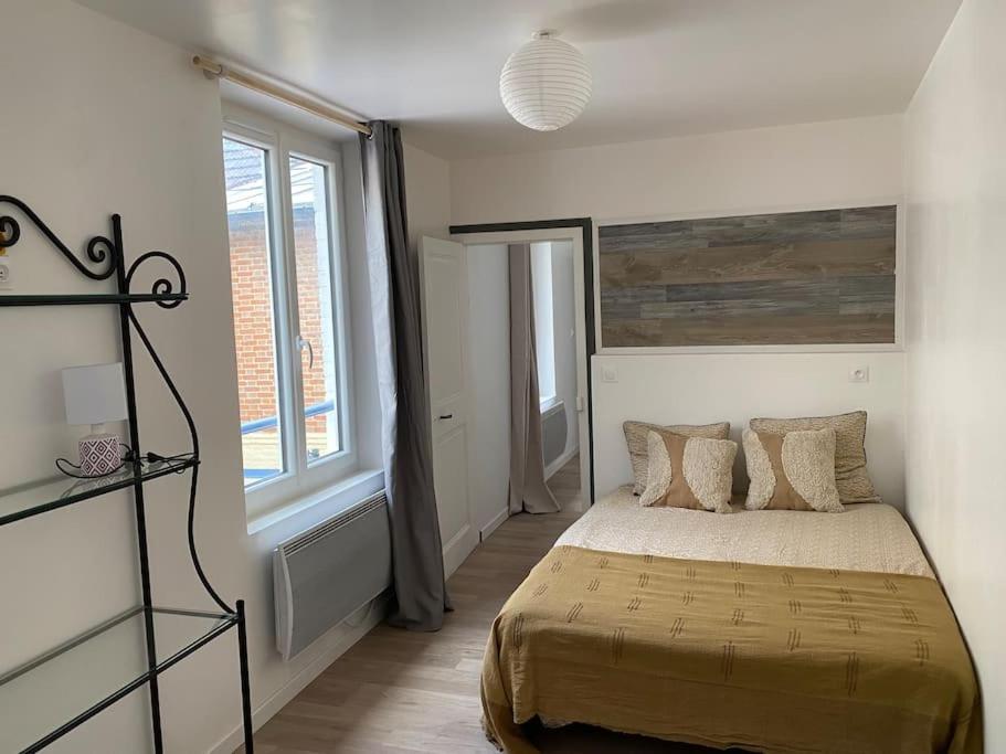 une chambre avec un lit et une grande fenêtre dans l'établissement Grande maison au centre Ville des Andelys, aux Andelys