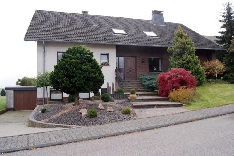 ein Haus mit einem Hof mit Felsen davor in der Unterkunft Ferienwohnung Hedi in Mastershausen