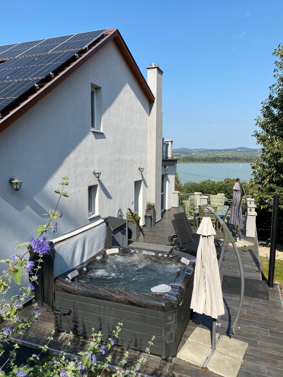 a hot tub on a deck next to a house at Capre Tihany in Tihany
