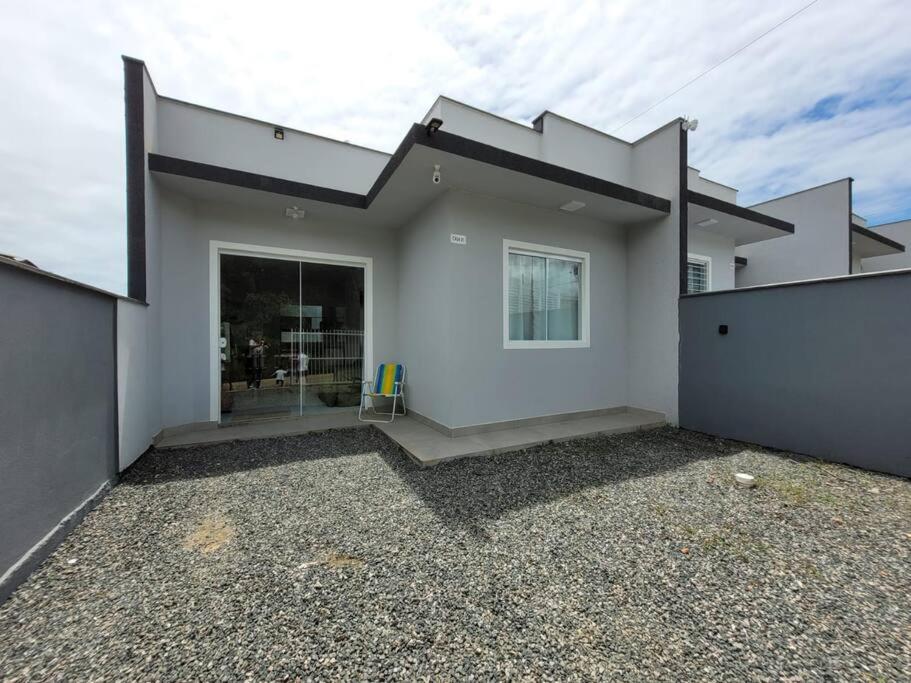 a white house with a large glass door at Casa de praia com wi-fi in Barra Velha