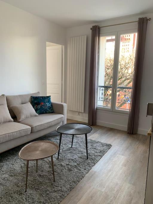 un salon avec un canapé et deux tables dans l'établissement Charmant 2 pièces rénové parc des expositions porte de Versailles, à Vanves