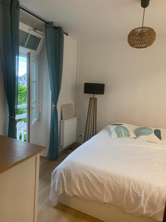 une chambre avec un lit blanc et une fenêtre dans l'établissement Charmant T2 meublé plein centre et proche plage, à Dinard