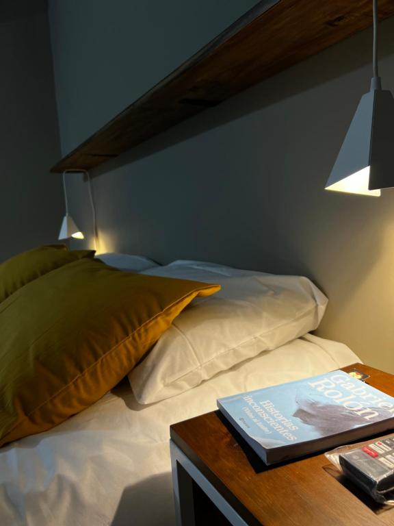 a bedroom with a bed and a table with a book at Alquiler Temporario Perico 1 in Perico