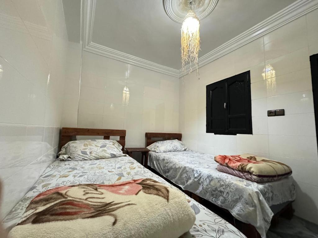 塔哈佐特Jada surf house taghazout的天花板客房内的两张单人床