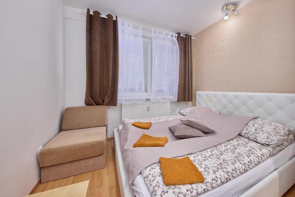 a bedroom with a bed and a chair in it at Destiny apartment in Bratislava
