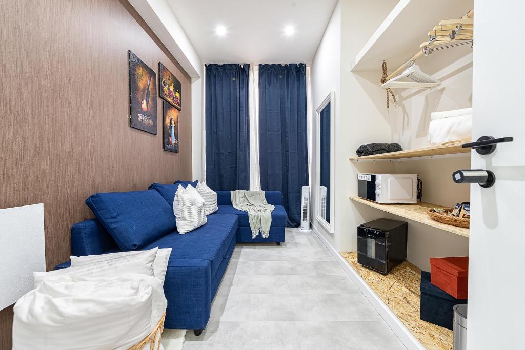 a living room with a blue couch in a room at Rooms Canteras Boutique Hostal in Las Palmas de Gran Canaria