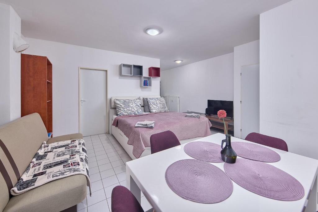 a living room with a table and a bedroom at Relax apartment in Bratislava