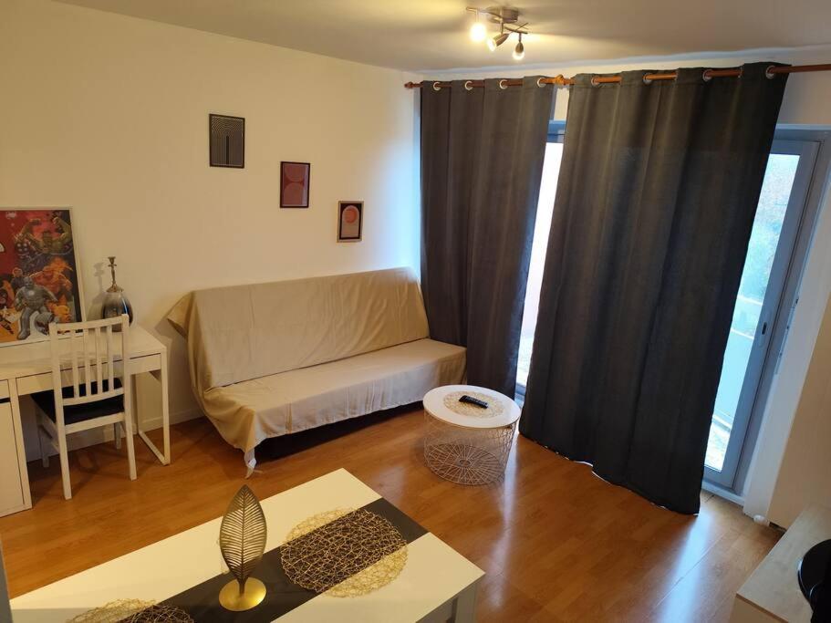 un salon avec un canapé et une table dans l'établissement Idéalement situé pour tous III, à Dijon