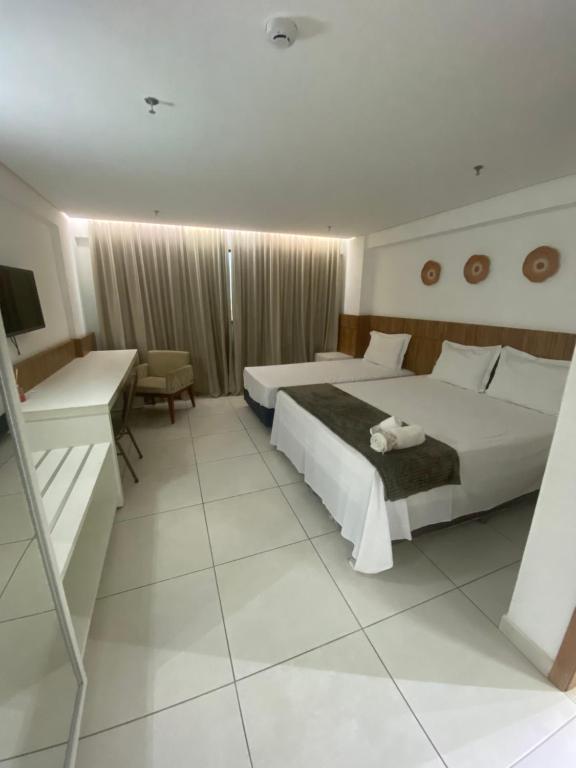 una camera d'albergo con due letti e una scrivania di Inova Flat no centro a Palmas