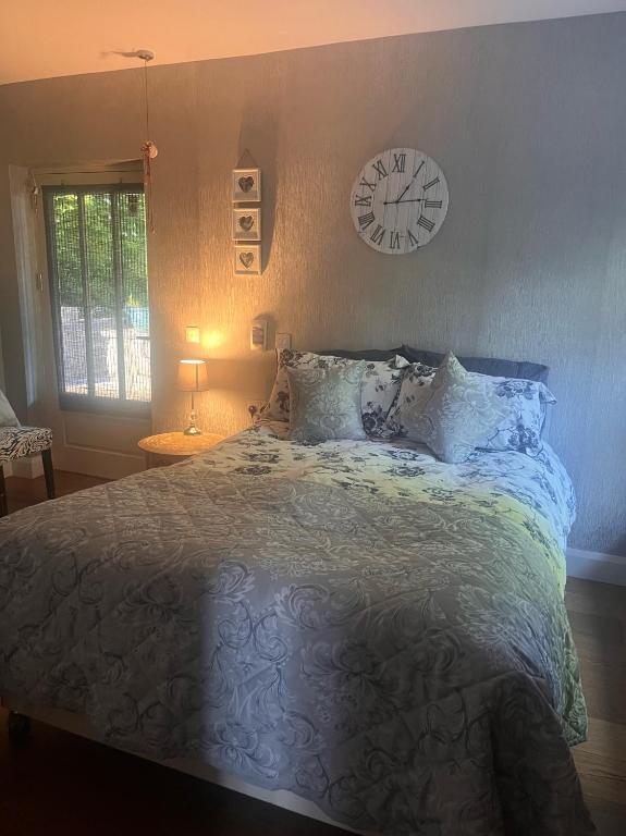 a bedroom with a bed with a clock on the wall at Stone Lodge B&B in Balrath