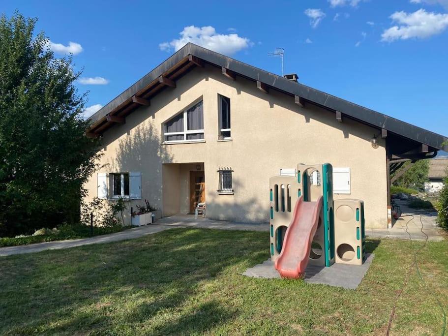 une maison avec toboggan devant une maison dans l'établissement Villa au calme entre lacs et montagnes, à Pers-Jussy