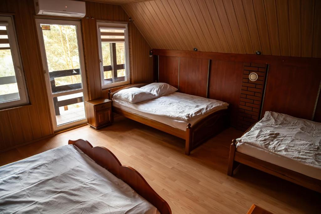 sypialnia z 2 łóżkami i 2 oknami w obiekcie Dom Parlinek agroturtstyka wędkowanie sauna jacuzzi w mieście Dąbrowa