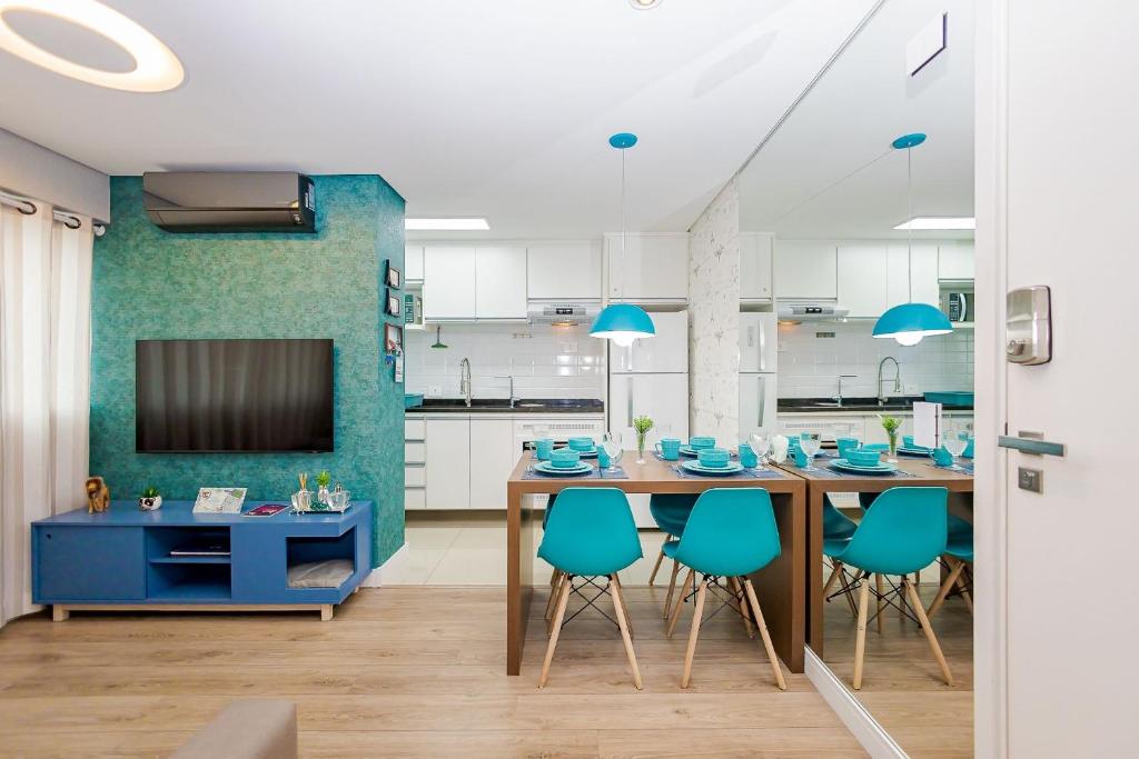 Una cocina con una mesa de comedor y sillas azules. en Apartamento 1 Quarto Lindíssimo, Garagem - SEV2402, en Curitiba