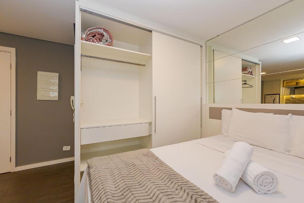 1 dormitorio con 1 cama blanca y 2 toallas en Studio para 4 pessoas no Seventh - SEV0702, en Curitiba