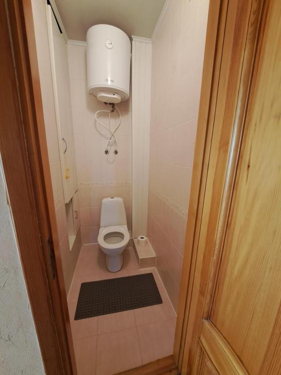 a small bathroom with a toilet and a light at Отдельная комната in Staţia de Cale Ferată Chişinău