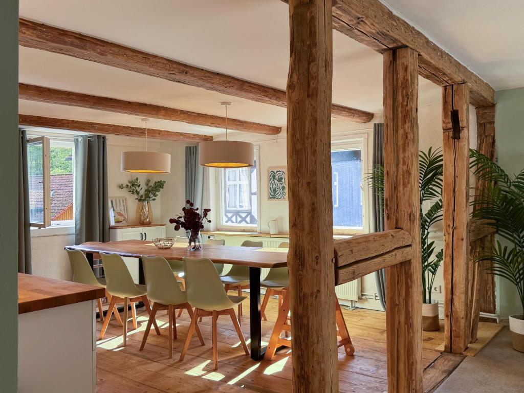 une cuisine et une salle à manger avec une table et des chaises en bois dans l'établissement Haus Ludwig - Saniertes Fachwerkhaus im Harz - 12 Personen, à Thale
