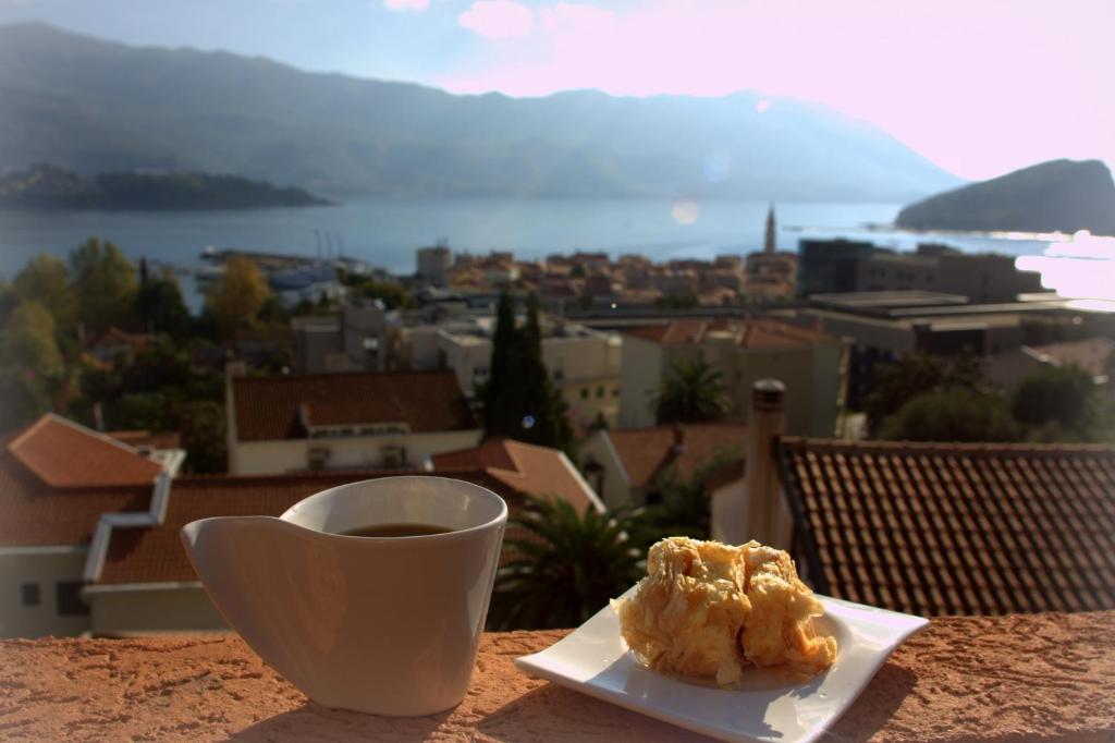 a cup of coffee and a pastry on a table at Villa Jovana Sea View in Budva