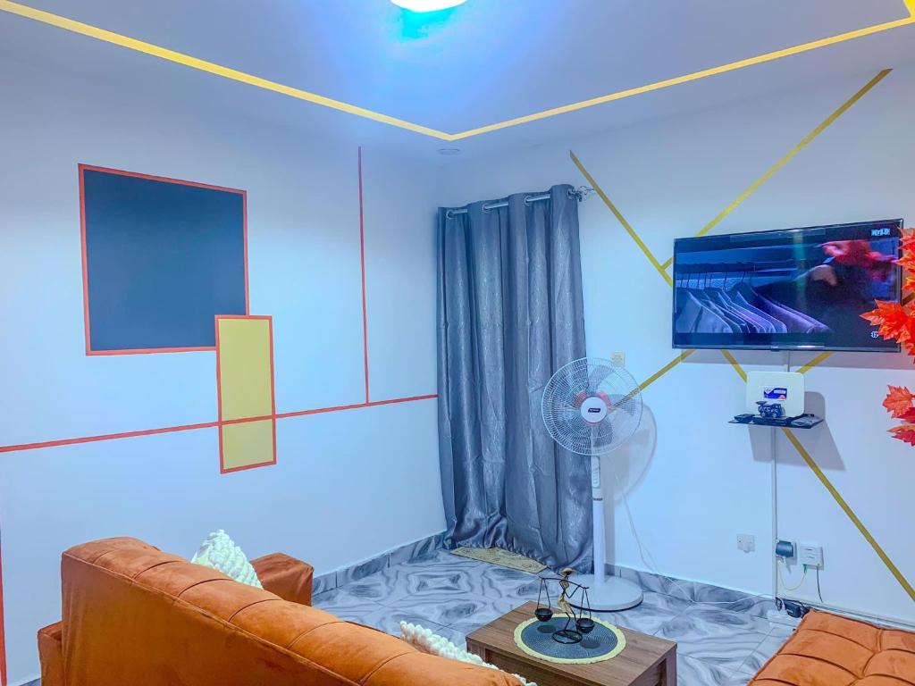 a living room with a couch and a flat screen tv at Havre de vie in Cocody