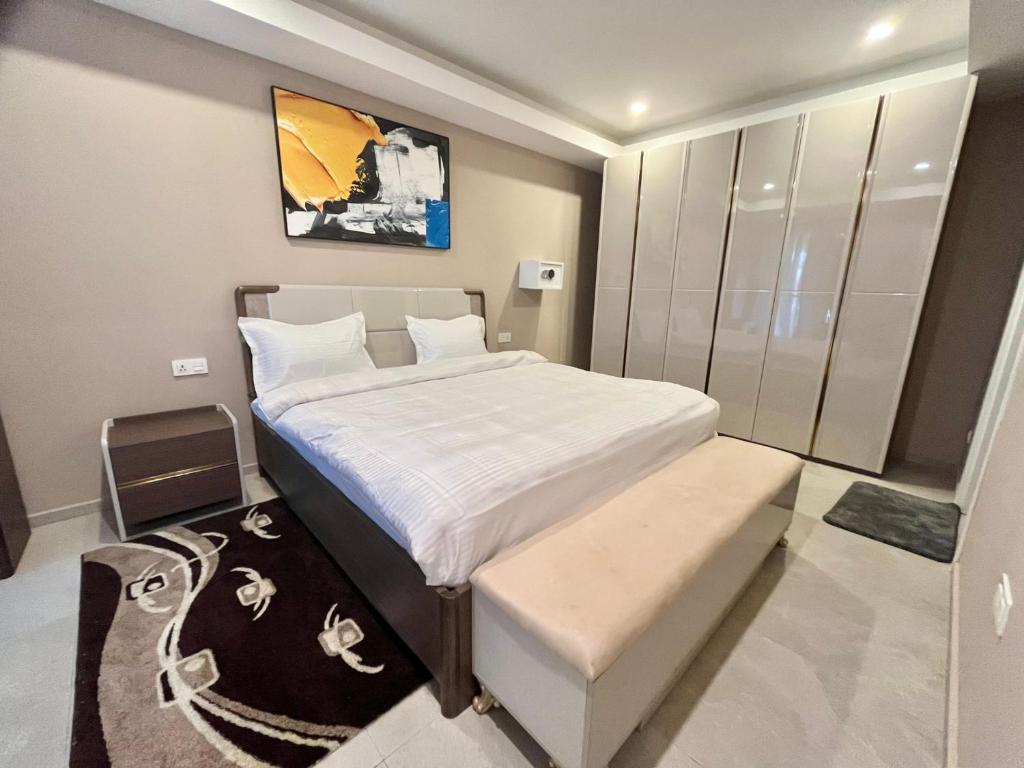 a small bedroom with a bed and a bench in it at Elegant 2-Bed Rooms at Kololi Sands in Kololi