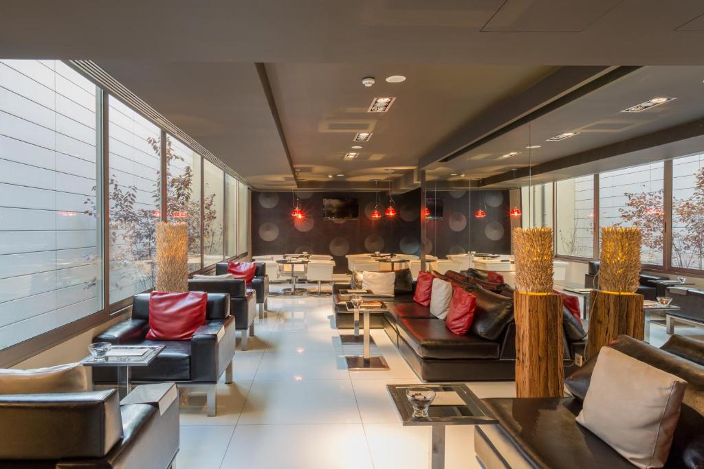 a restaurant with couches and tables and windows at Porto Trindade Hotel in Porto