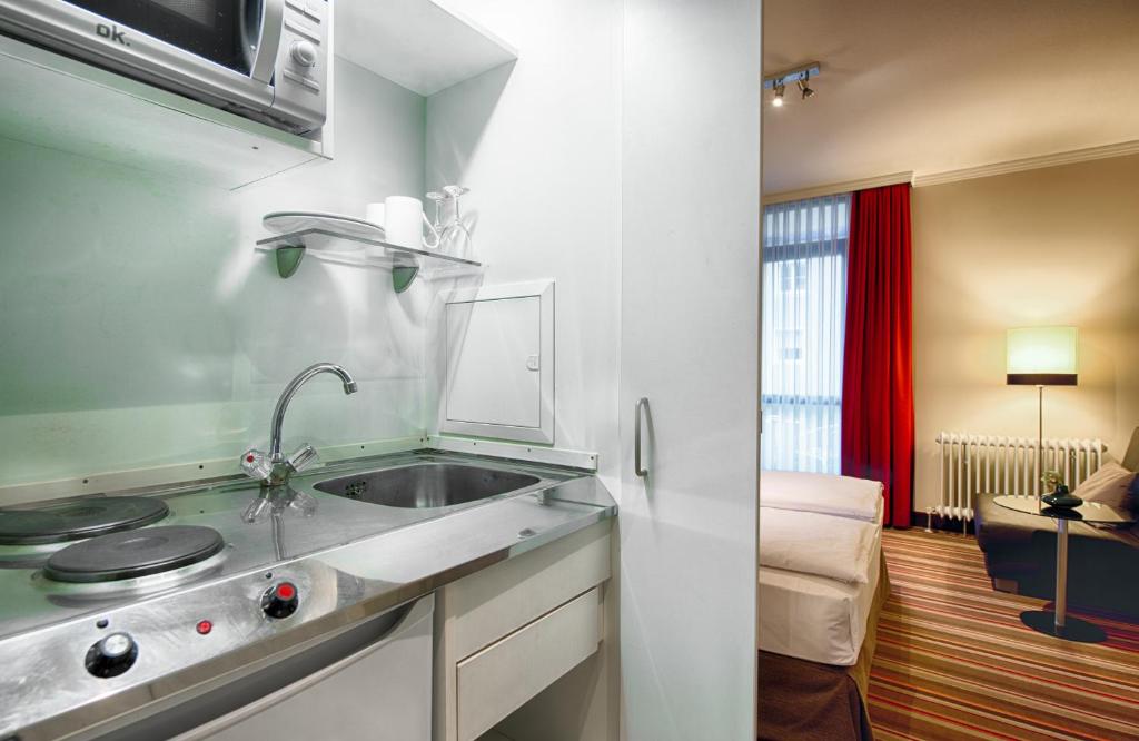 Kuchyň nebo kuchyňský kout v ubytování Leonardo Hotel & Residenz Muenchen