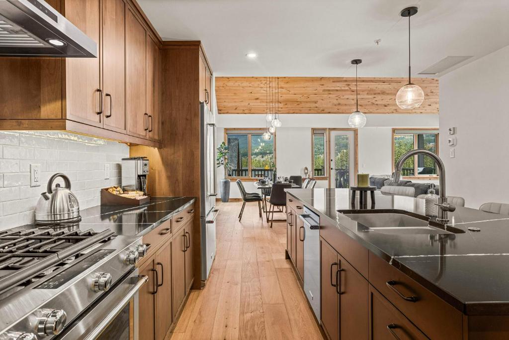 a kitchen with wooden cabinets and stainless steel appliances at Spring Creek Luxury - managed by Little Sister Getaways in Canmore