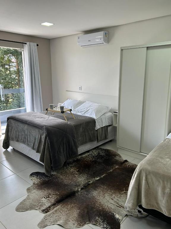 a bedroom with a bed and a large window at Vista da Serra. in Gramado