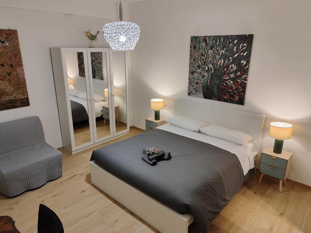 a bedroom with a bed and a chair and a mirror at A&B Vatican Domus in Rome