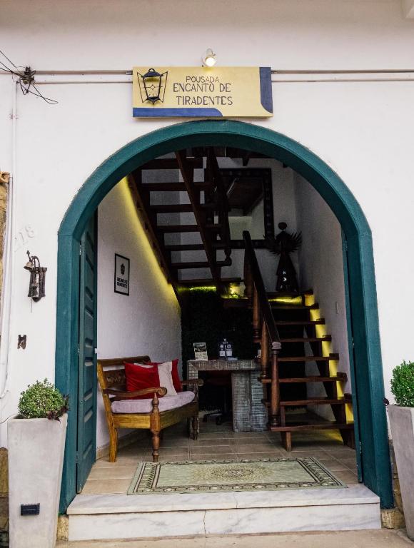 an entrance to a house with a staircase and a sign at Pousada Encanto de Tiradentes in Tiradentes