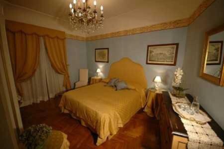 a bedroom with a bed and a chandelier at B&B La Porticella in Viterbo
