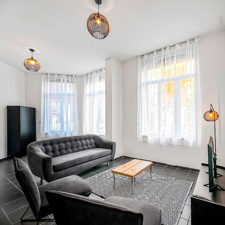 un salon avec un canapé et une table dans l'établissement Spacieuse maison, 4 chambres, Wi-Fi et Parking, à Tourcoing