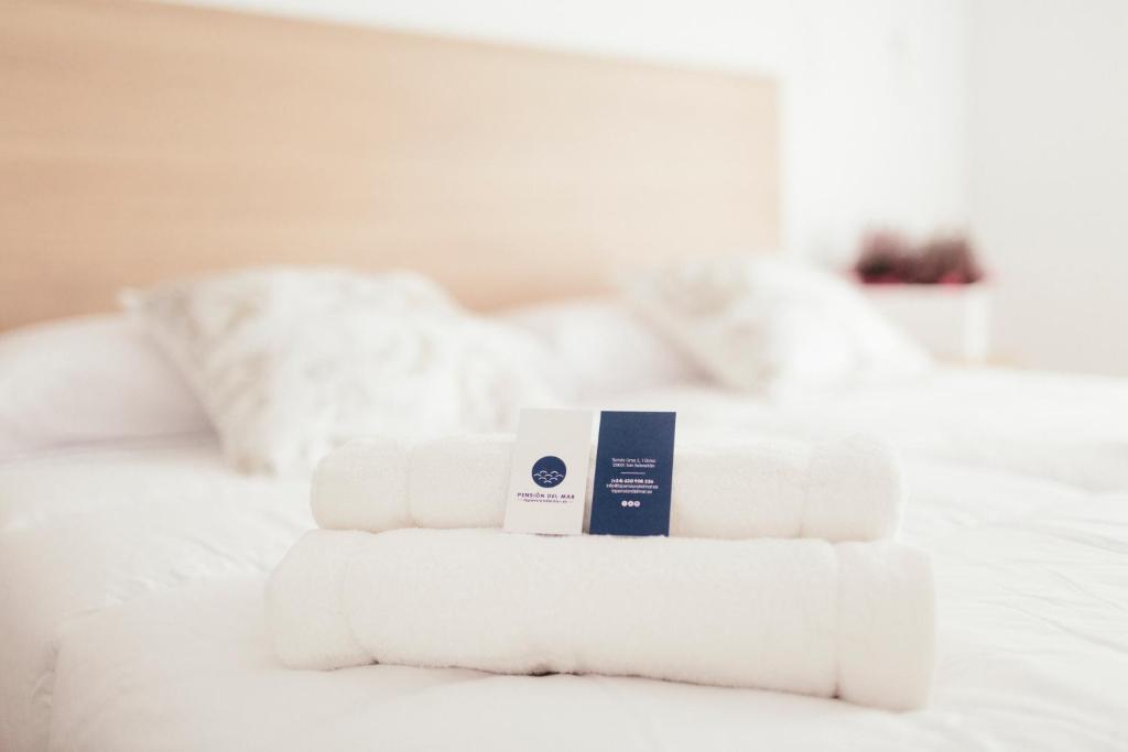 una pila de toallas sentadas encima de una cama en Pension Del Mar, en San Sebastián