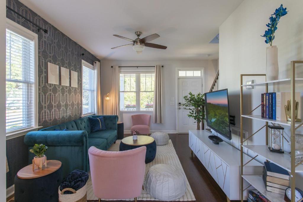 a living room with a couch and a tv at Fam-Biz Friendly 3BD with Fire pit & BBQ - Downtown in Raleigh