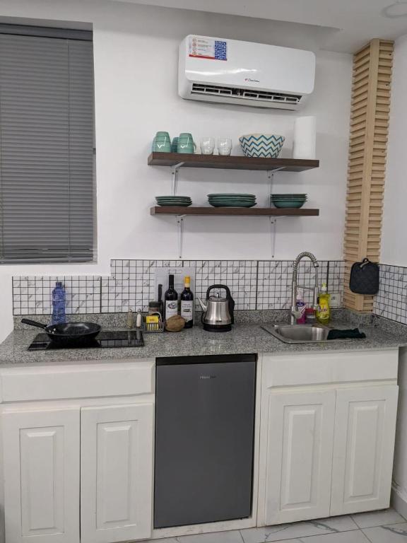 KinshasaL F Suites的厨房配有白色橱柜和黑色洗碗机