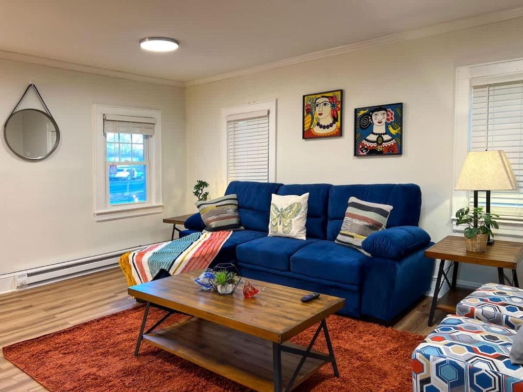 Una sala de estar con un sofá azul y una mesa. en Quaint Renovated Single Family, en Matawan