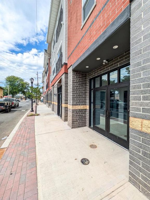 an empty sidewalk in front of a brick building at 322 Brand New 2 Bdr 1 KIT 2 BTH 1 LIV in Dunellen