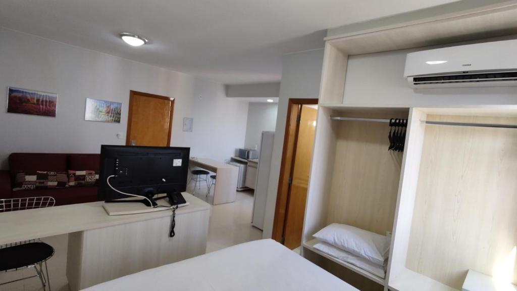 a room with a bed and a television on a counter at Golden Dolphin Supreme in Caldas Novas