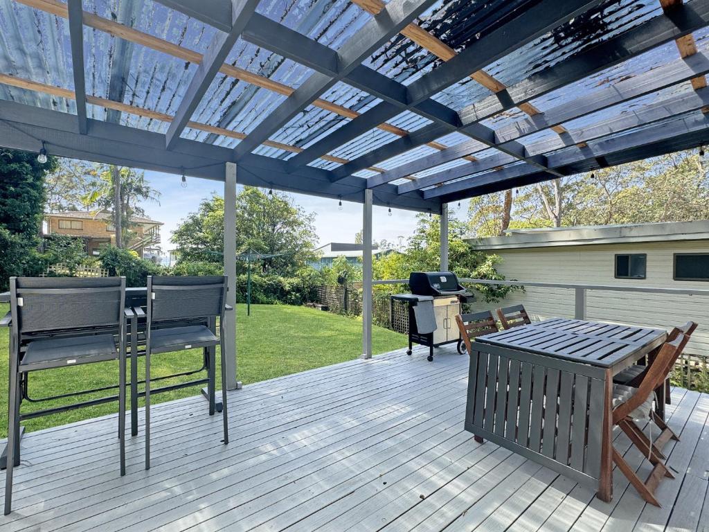a wooden deck with a pergola and a table and chairs at Pet-Friendly 2-Bed Beach House with Garden & BBQ in Surf Beach