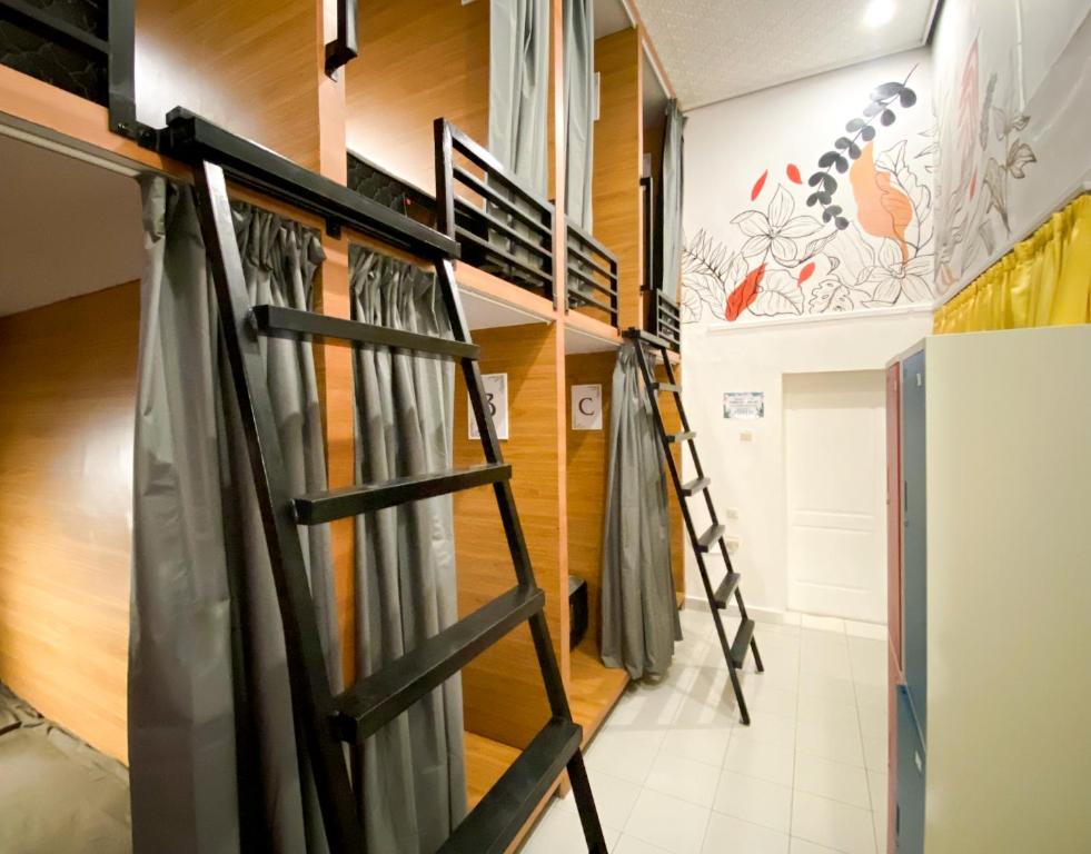 a room with bunk beds and a ladder at Snooze Malang in Malang