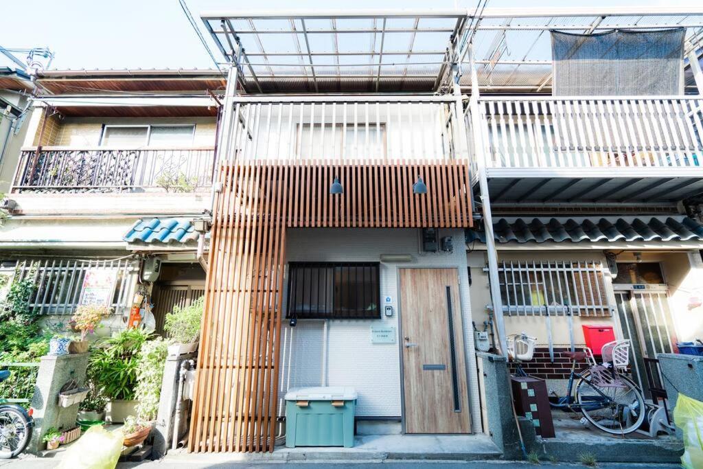 a building with a wooden facade with a door at 天下茶屋vii 忙しい旅行中も ゆったりした時間を過ごせるお部屋 お勧めコーヒーと共に in Osaka