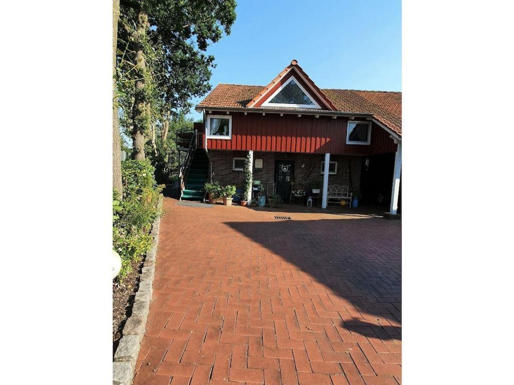 a house with a brick driveway in front of it at Ranchhouse Dogs and horses welcome in Aurich