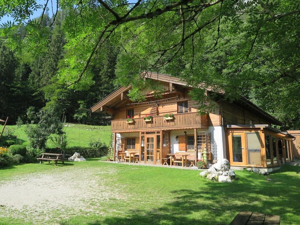 a log cabin with a lawn in front of it at Schossbach in Haus Waldwinkel in Aschau im Chiemgau