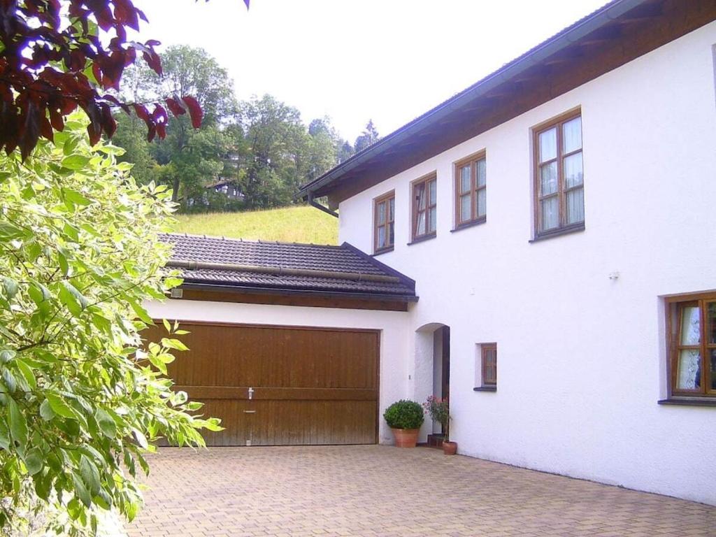 Casa blanca con puerta de garaje marrón en Haringer Comfortable holiday residence, en Schliersee